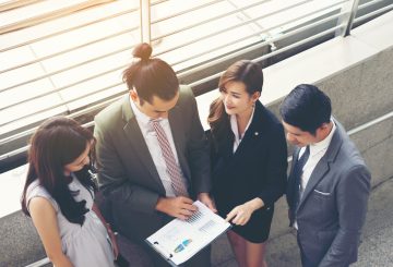 Business teamwork with document in her hands, watching some interesting content during lunch break